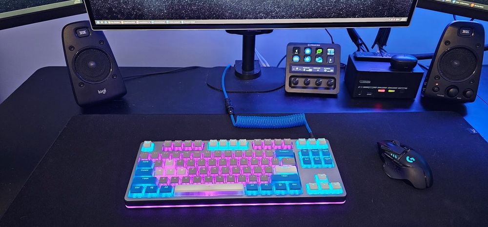 Photography of a desk containing a multicolored keyboard.