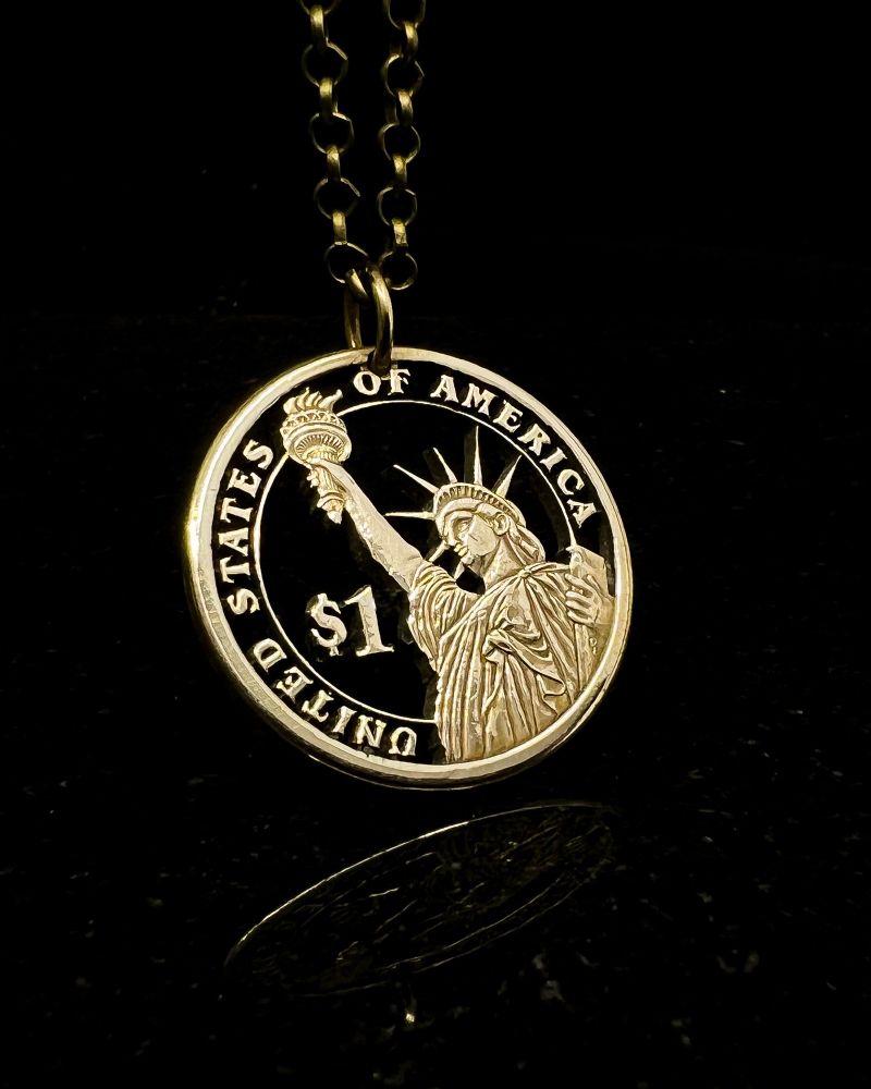 U.S. one dollar coin featuring the Statue of Liberty, hand-cut with a jeweler’s saw. 