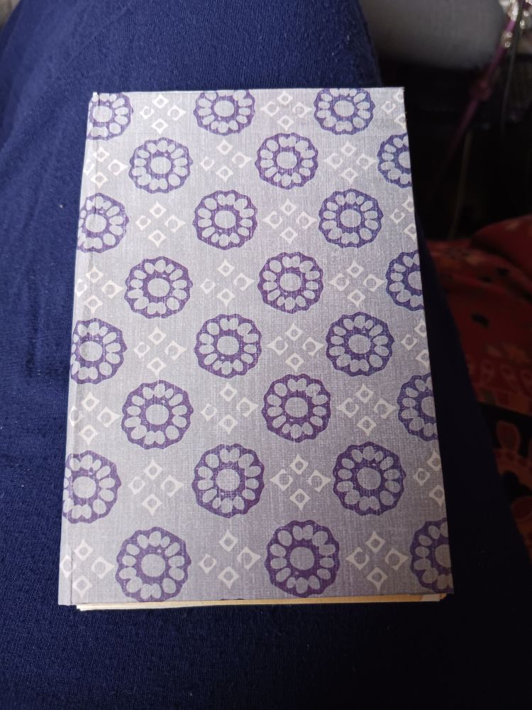 Homemade art journal With blue flowers and white diamond shapes stamped on the paper