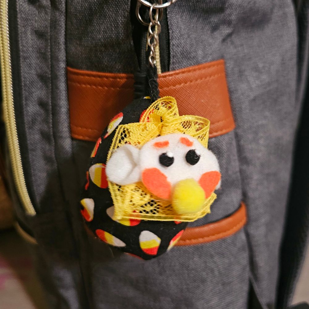 A clown candy corn plush keychain 