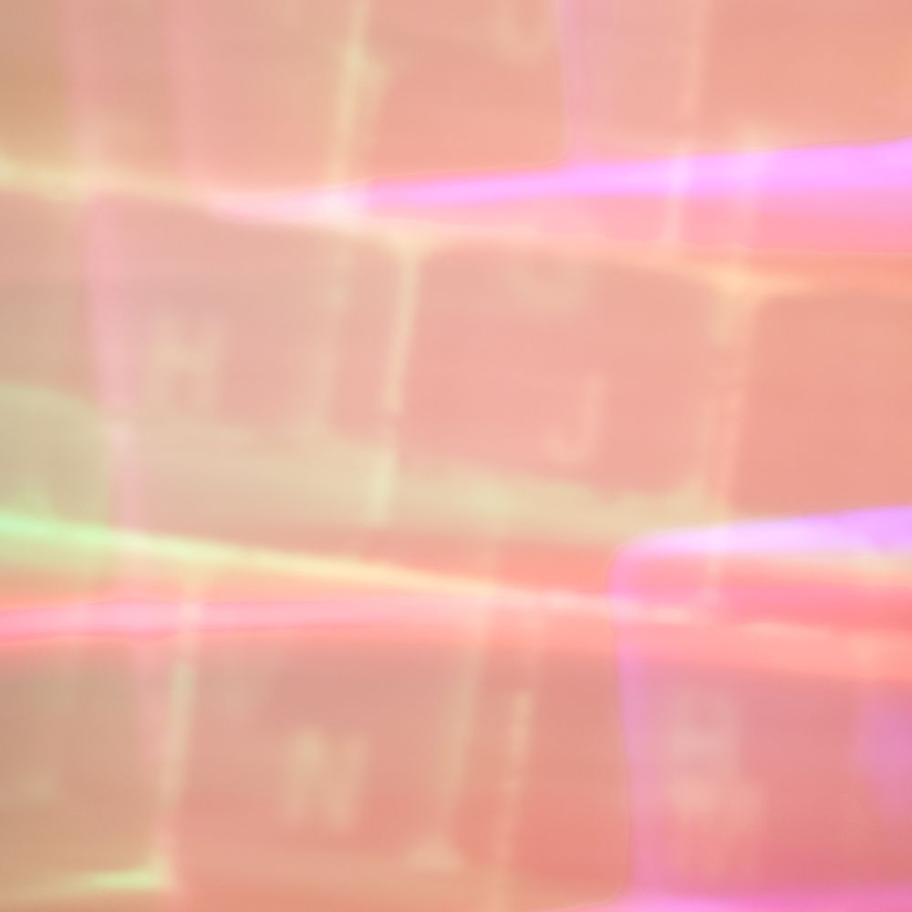 An overexposed, abstract close-up photo of a pc keyboard featuring multicolored light patterns in shades of blue, yellow, pink, and orange. The image has a soft, dreamy quality with faint outlines of keyboard keys, creating a surreal, distorted effect. The overall look is hazy and diffused, blending the bright colors into a smooth, ethereal pattern that suggests a keyboard but lacks clear details.