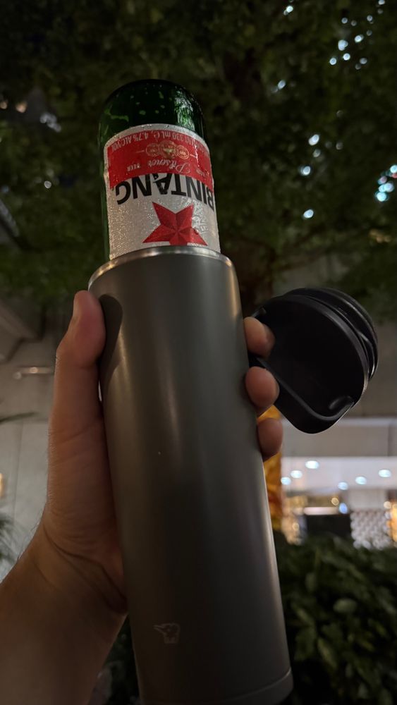 氷の入った水筒にビールを注いで飲んでる人