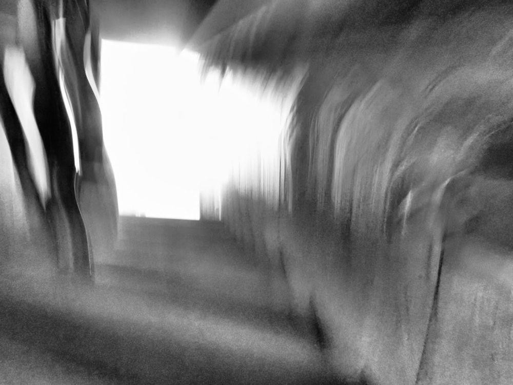 Verwischtes Bild, schemenhaft ist ein Radfahrer vor hellem Hintergrund erkennbar 