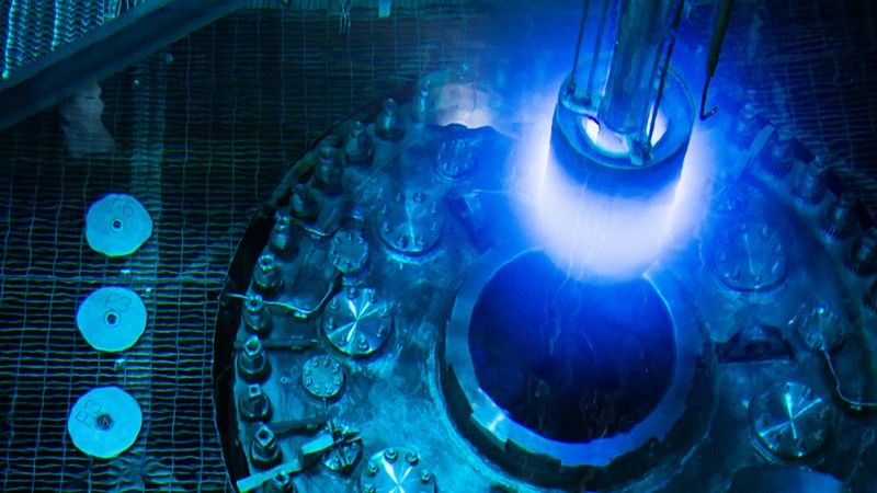 Photo of a fuel element being taken out of the High Flux Isotope Reactor at Oak Ridge National Laboratory. The element is glowing with blue/violet Cherenkov radiation.