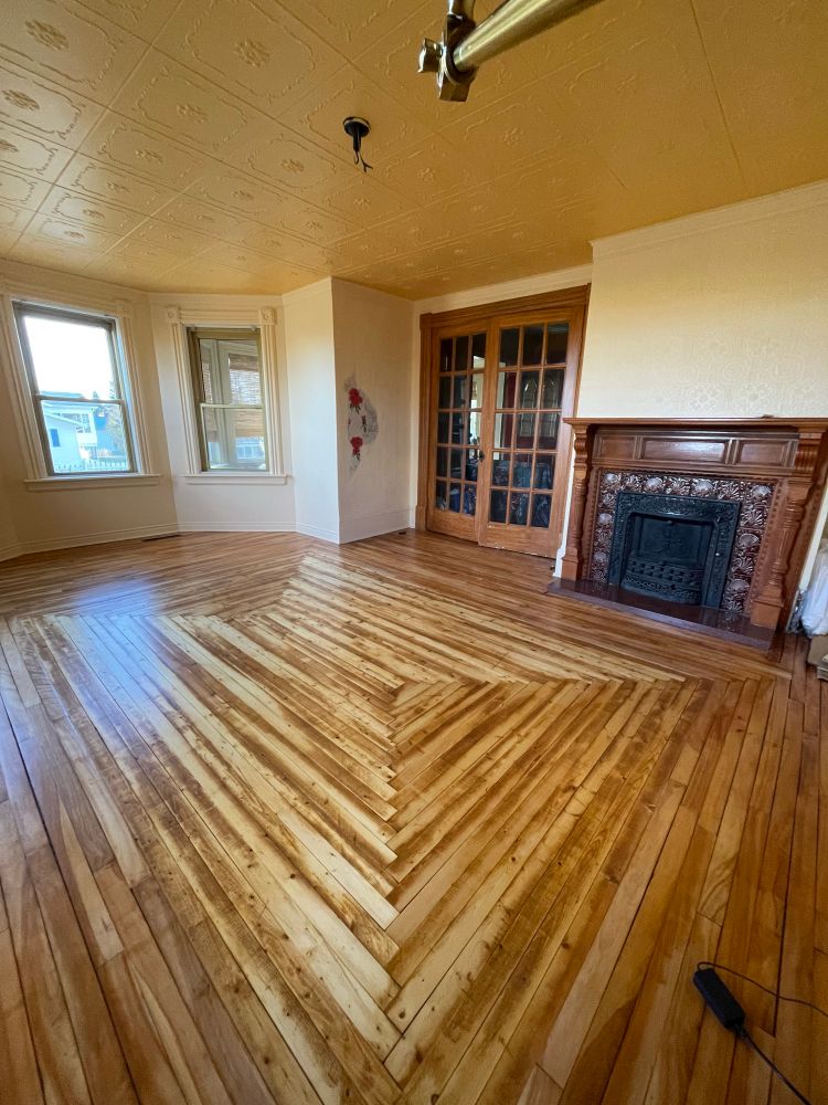 My living room in my older home - I refinished the hardwood floors, pulled down the old plaster walls and put up drywall, did the trim and painted it all "creamy mango" and I love it. There's also an original fireplace mantle and french doors. And a little patch of the original (first layer!) wallpaper, which I'm not sure what to do about yet.
