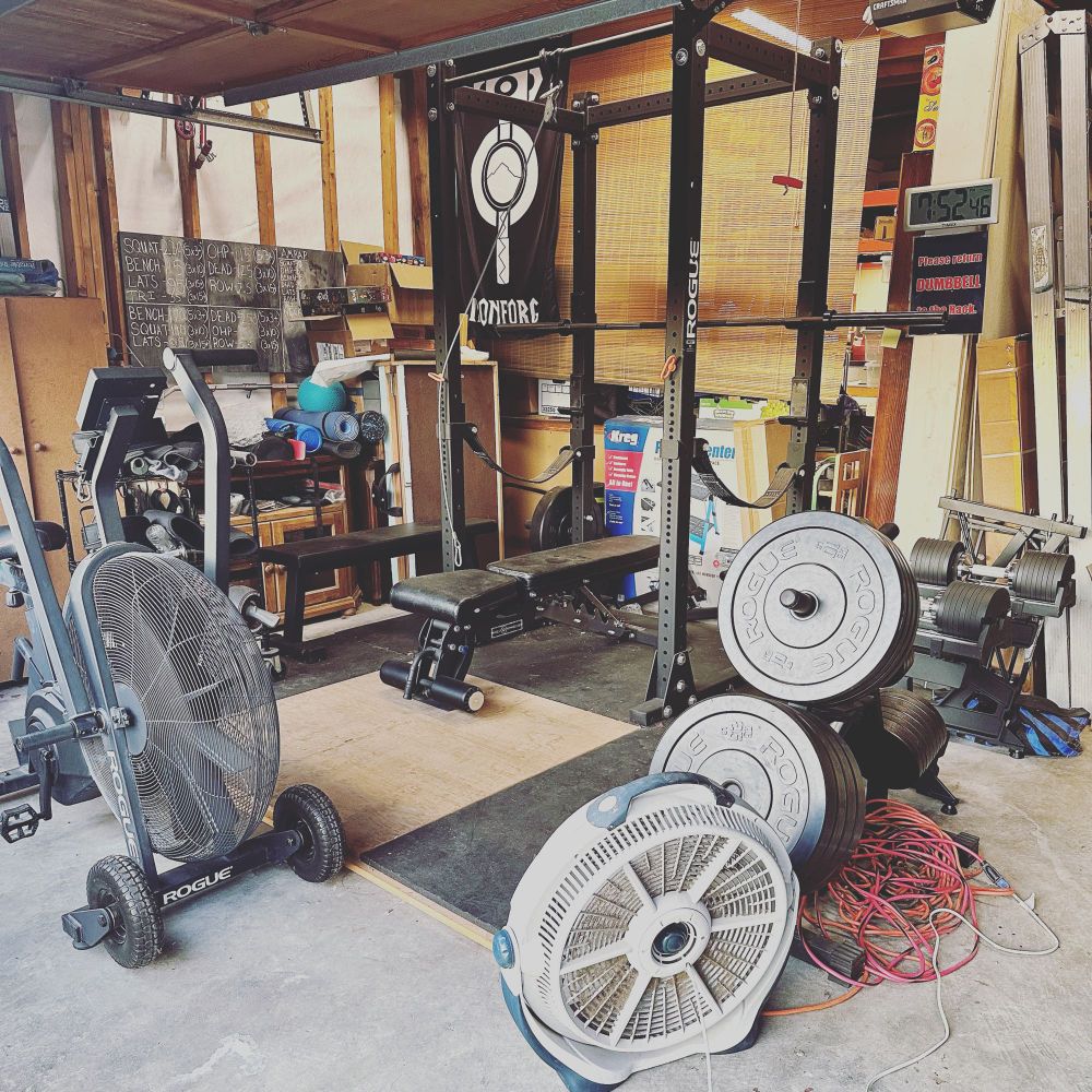 A garage gym with power rack, weight bench, and various other accessories.