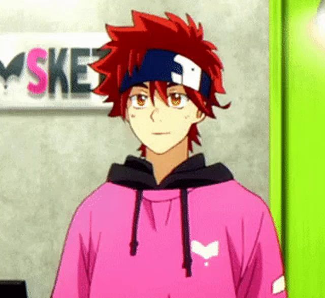 a young man with red hair is wearing a pink hoodie and a headband .