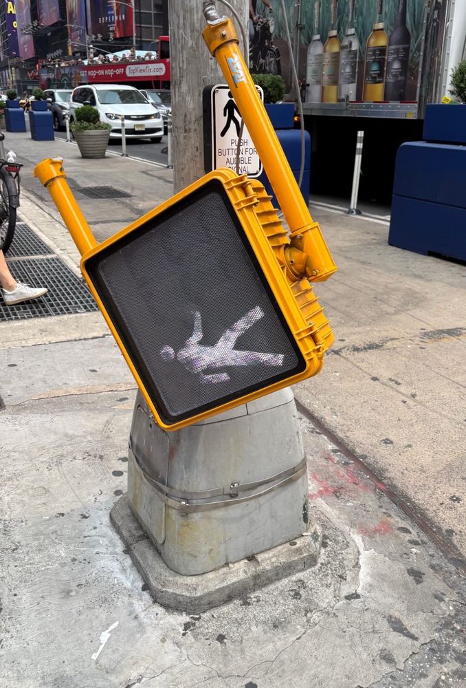 A walk sign that has fallen over but is still functional somehow 