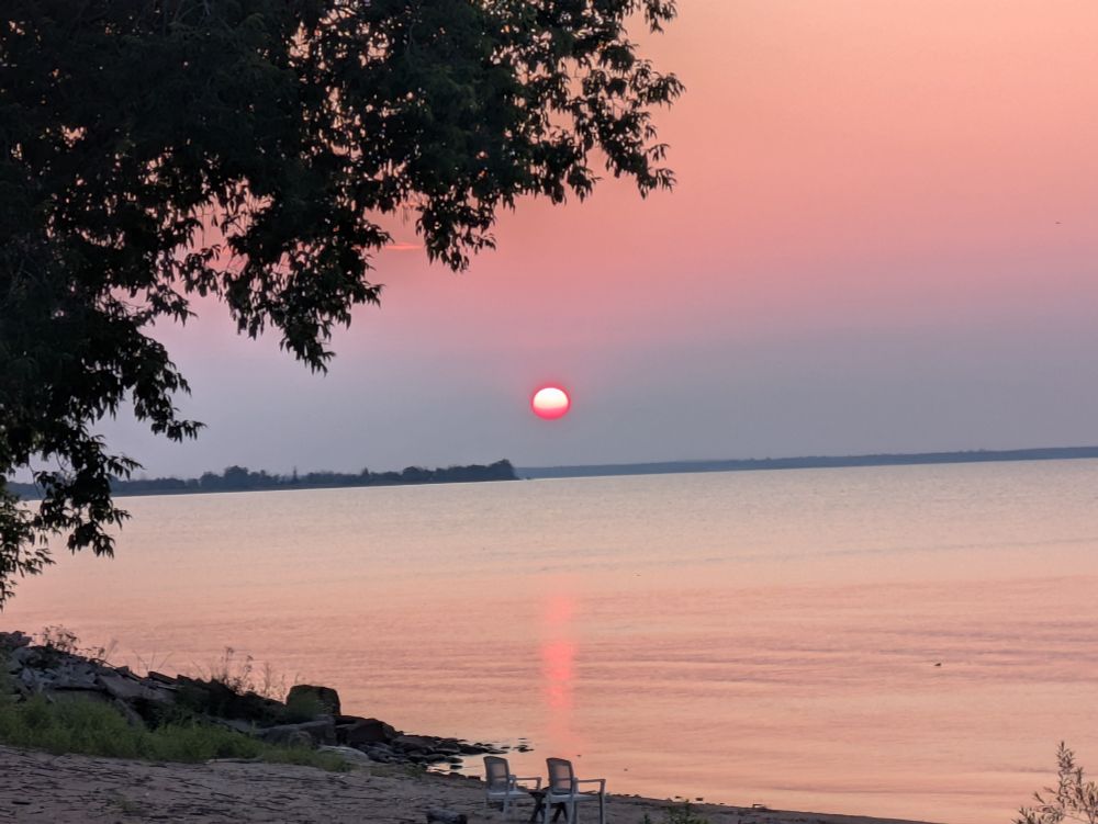 A sun tinged with pink rising above the Stonington Peninsula in Michigan's Upper Peninsula