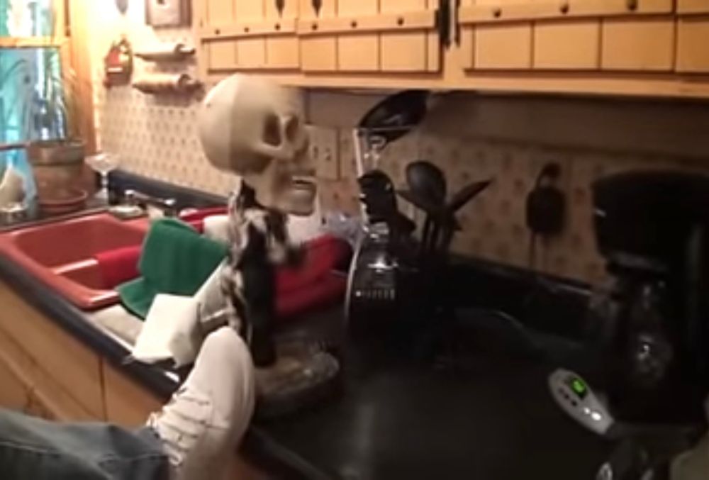 A man extends his leg to deflect the toy skeletons power.