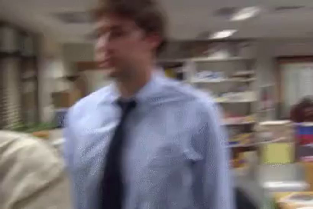 a man in a blue shirt and tie is standing in an office