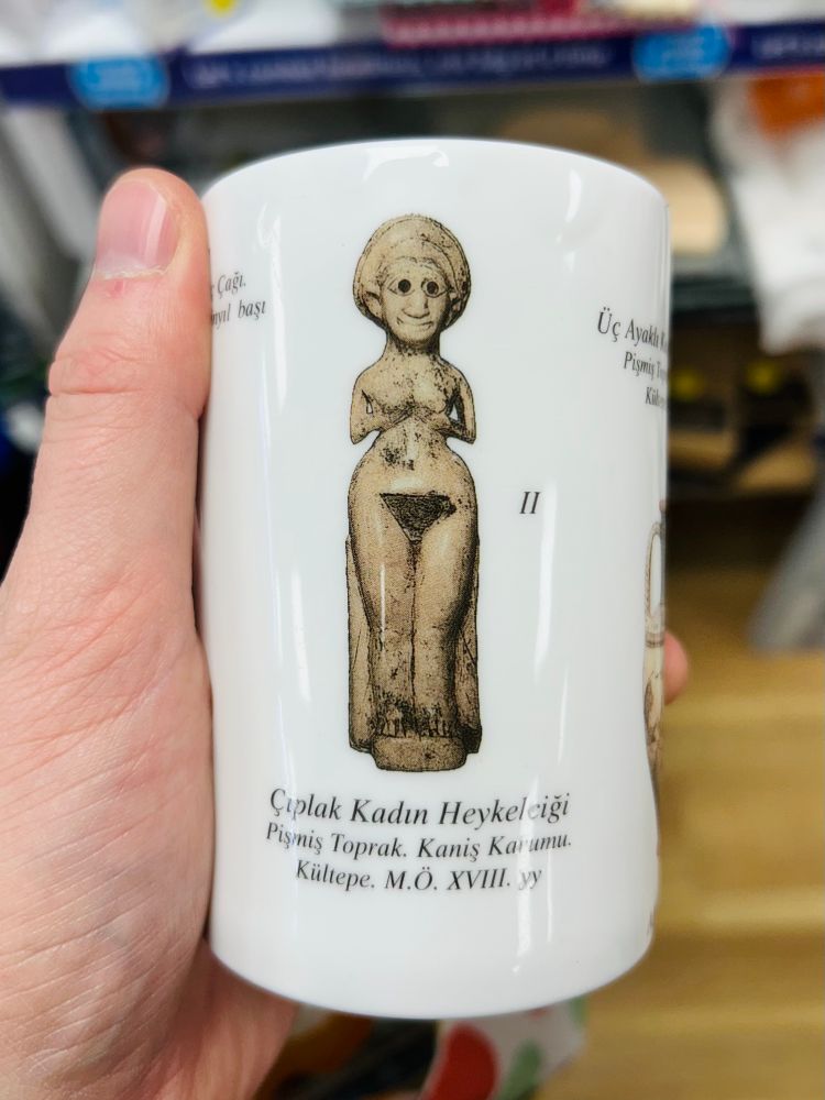 mug with a design featuring an archaeological figure with a kind face 