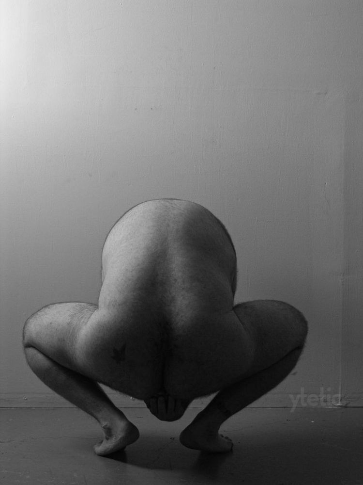 4. Facing away from us, crouched, reaching back and under with one hand to hold his nuts.