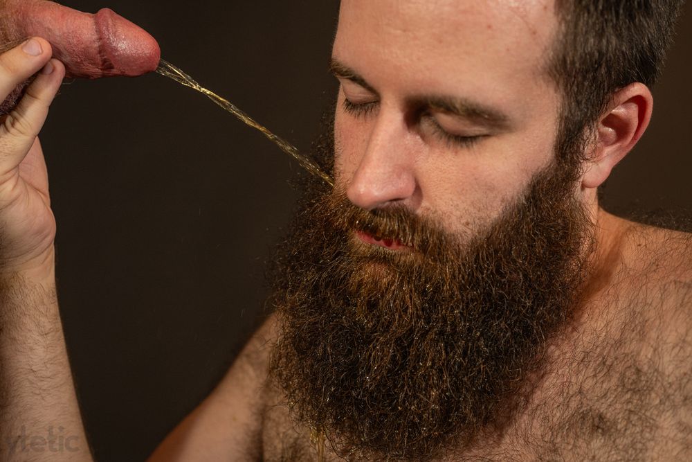 Four low key colour photos on black backdrop. Closeup on CLD's face, DD's cock half-hard; progressive stages of DD saturating CLD's beard with piss. 
