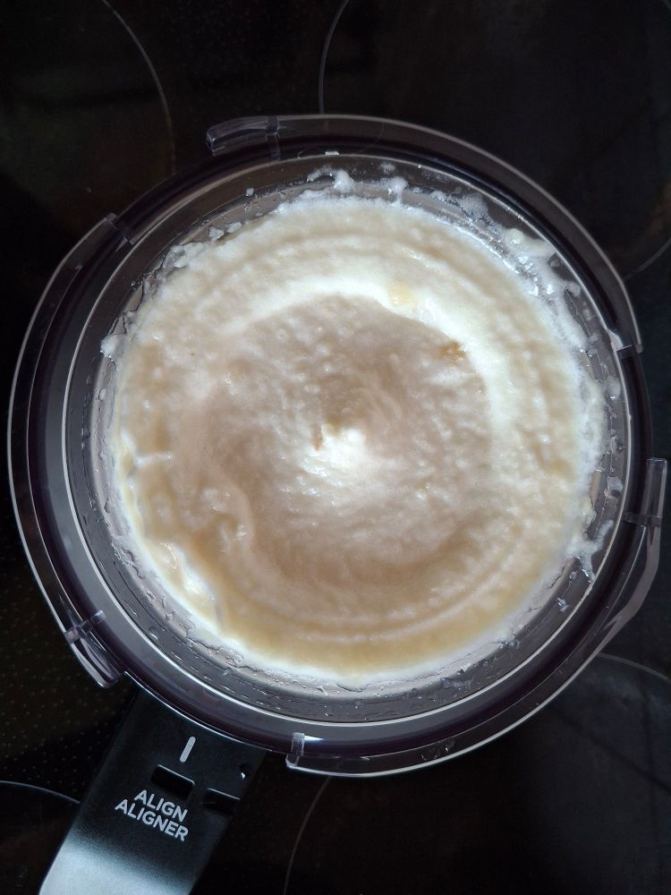 Pineapple sorbet in the bowl of a Creami ice cream maker.