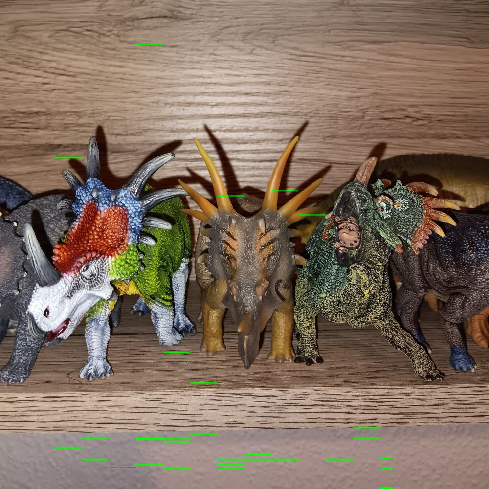 Drei Styracosaurusfiguren, ein in den Farben eines Grünen Aras umbemalter von Schleich in laufender Pose, einer von PNSO der mit gesenktem Kopf droht und ebenfalls läuft, und einer von Papo, der stehend den Kopf hebt und zu rufen scheint.