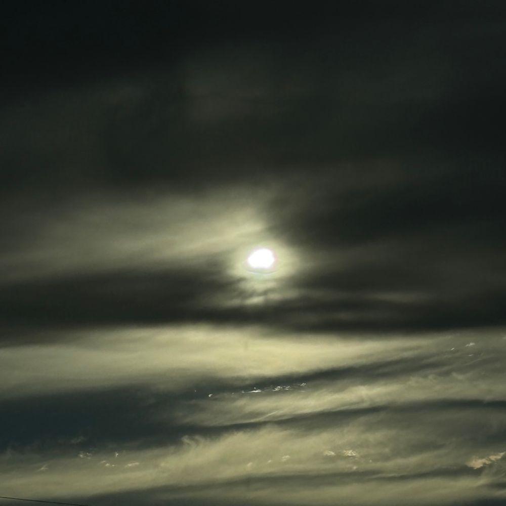 The setting sun obscured by clouds. 