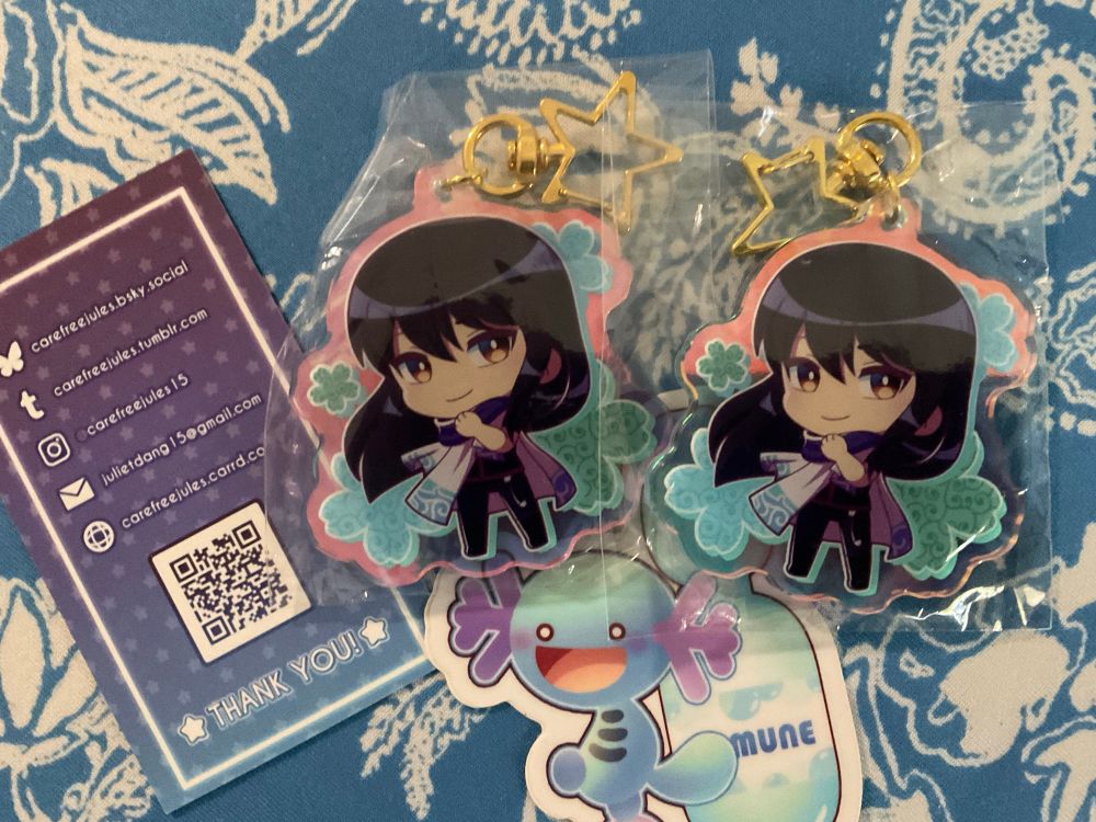 Two keycharms of Katsura from Gintama in the Zunbora alien jersey which happens to be Gintoki's default outfit. There was an official merch contest to see who looked the coolest in it, my personal favourite was Katsura.

Also a Wooper + Ramune sticker.

Artist's business card:
carefreejules.bsky.social
carefreejules.tumblr.com
@carefreejules15 on Instagram
carefreejules.carrd.co