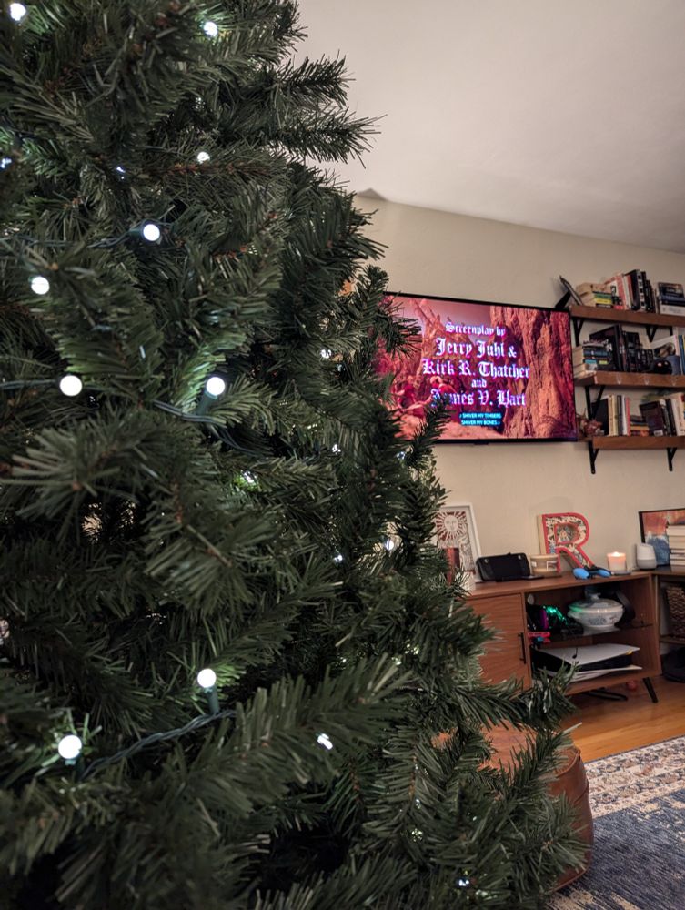 A lit, but undecorated Christmas tree in front of the opening credits of Muppet Treasure Island.