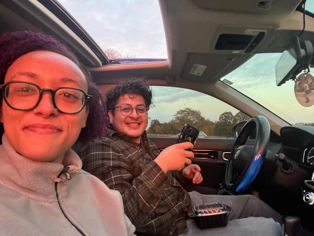 two people sitting in a car smiling in a selfie