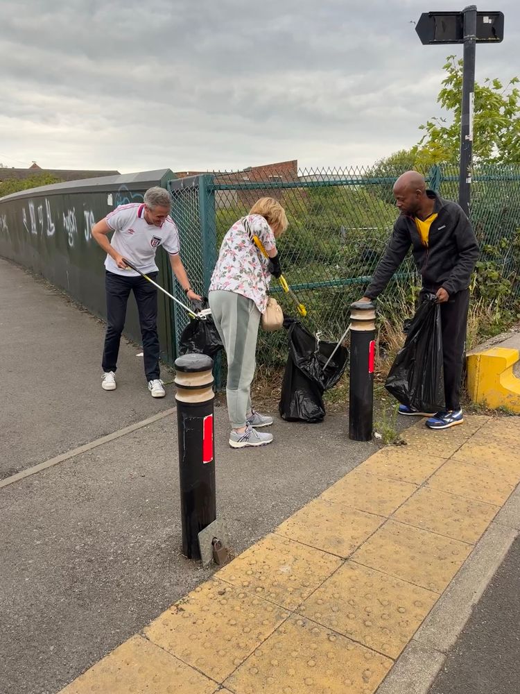 3 people picking litter