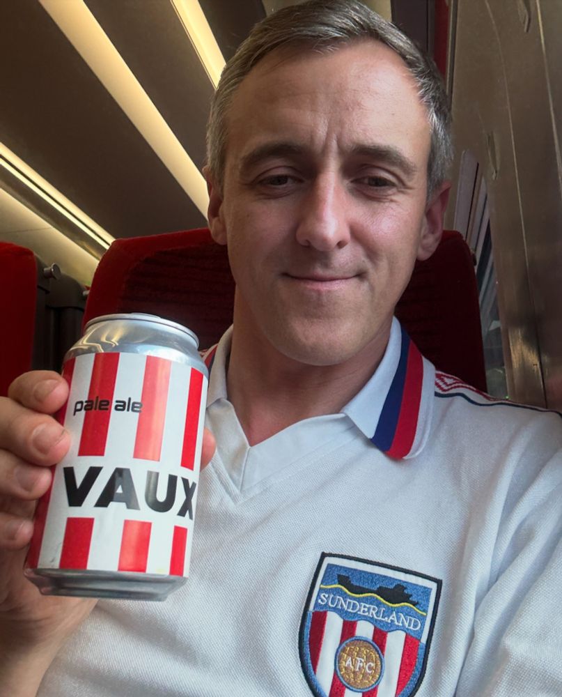 Holding a Vaux red and white beer can on the train