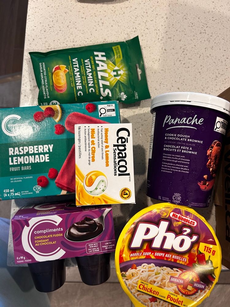 A counter with assorted snacks and throat meds 