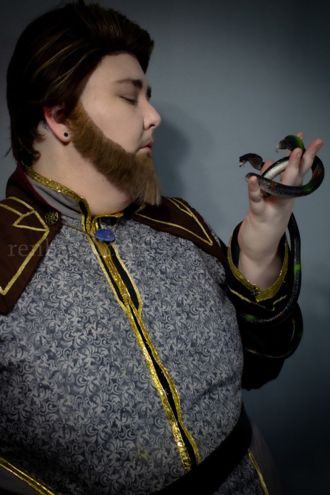 Ren in Viren cosplay, holding a rubber snake that has two heads. The tail is wrapped around Ren's arm.