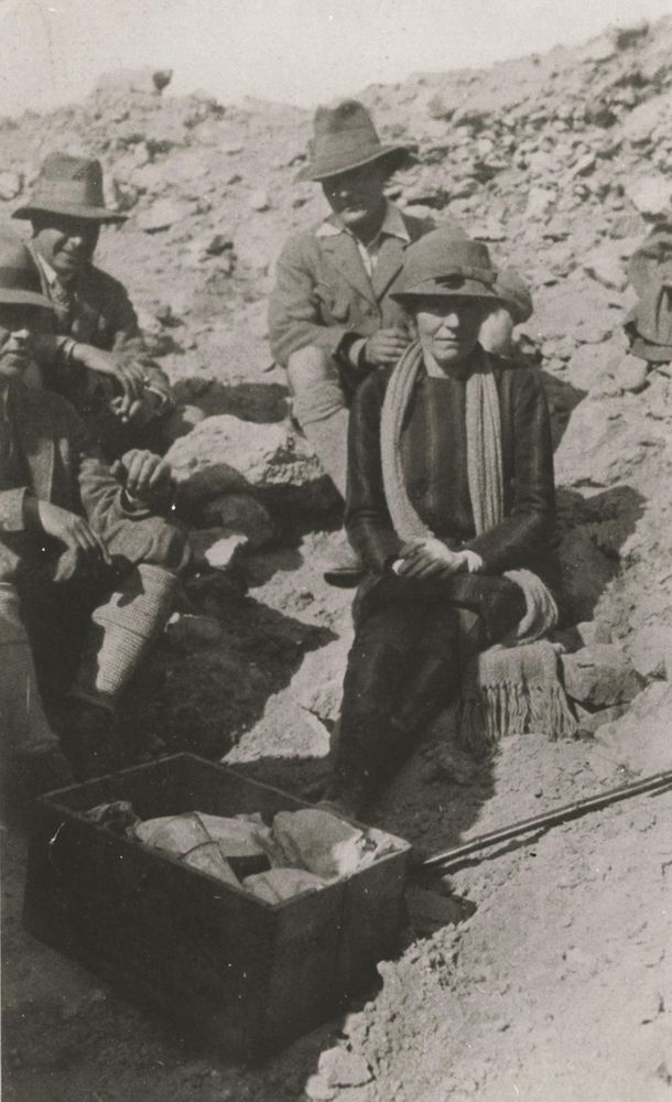 A photo of Gertrude Bell seated at an excavation site with male colleagues. 