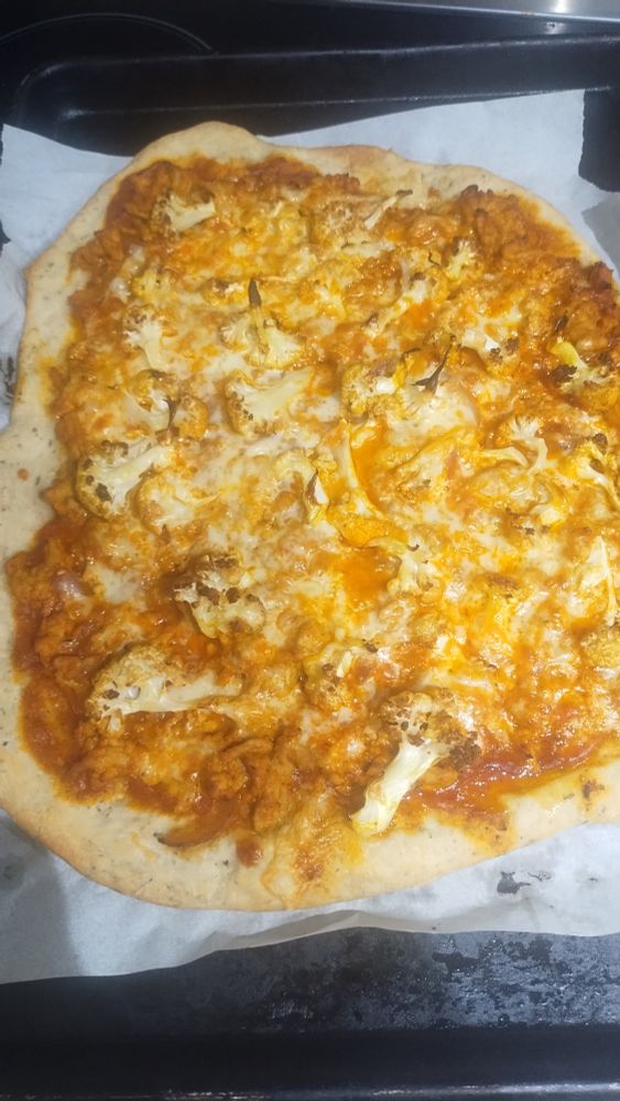 Pizza with tandoori chicken, onions and cauliflower