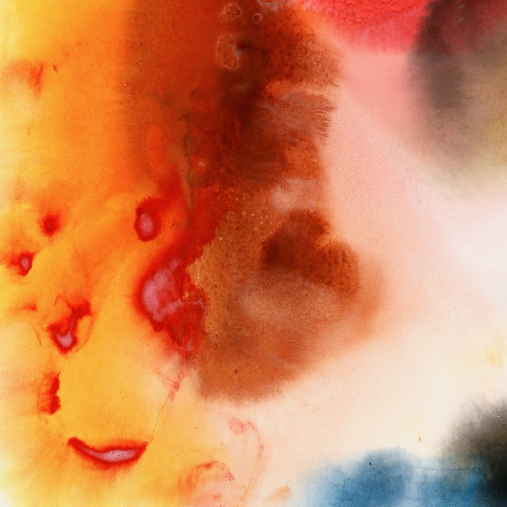 Detail of a colorful stain painting on a large sheet of Arches Watercolor Paper of abstract shapes in rose, yellow, brown and blue and black in an organic swirling composition