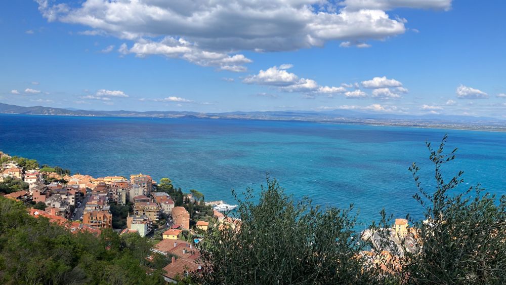 Aussicht aufs Meer mit rötlichen Häusern im Vordergrund