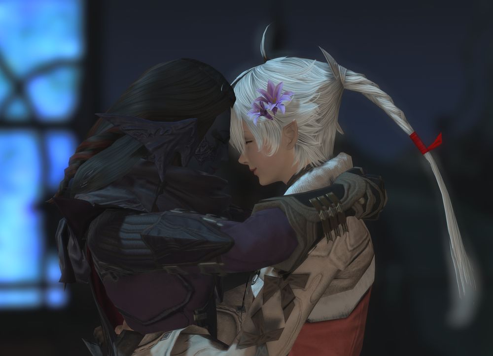 A close up shot as Sari and Alisaie lean in and rest their heads against each other with their eyes closed and content smiles.