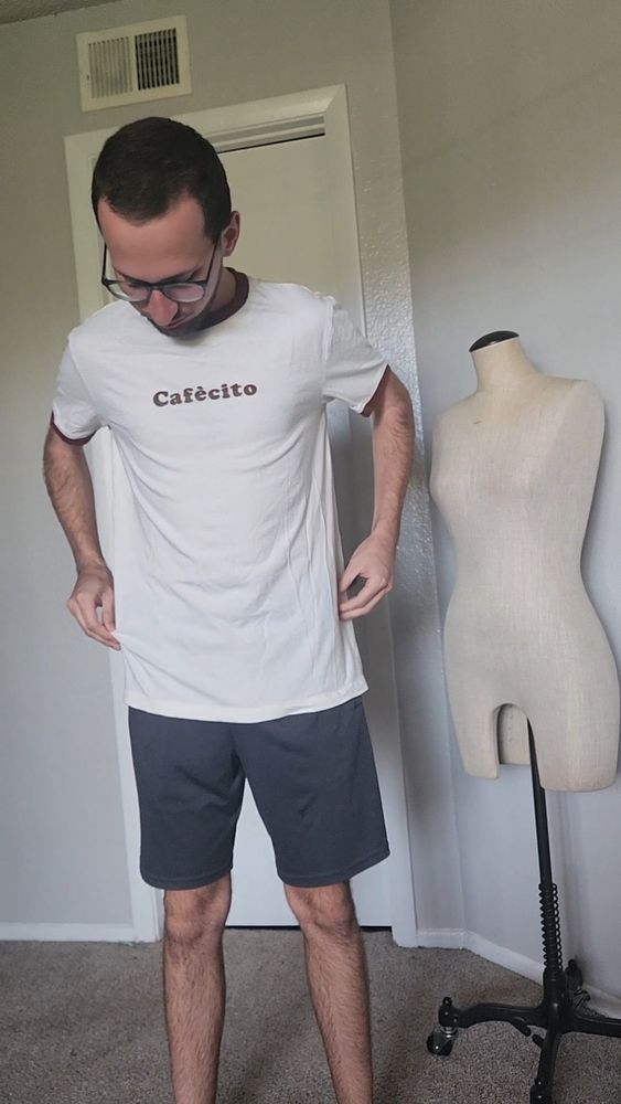 Me standing up showing my white "cafecito" shirt before cropping it