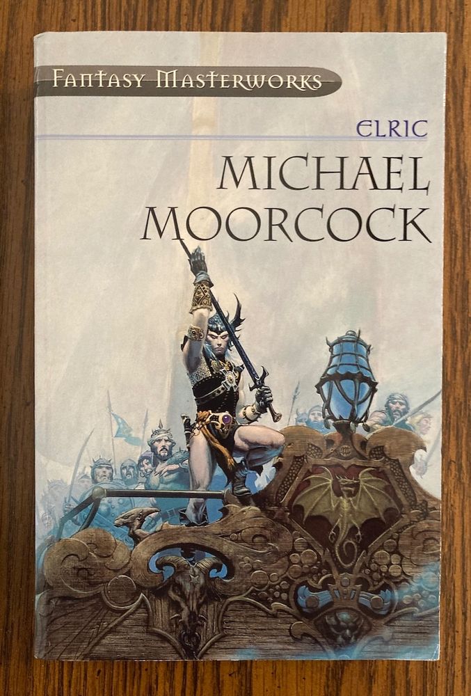 Cover art for the 2001 Fantasy Masterworks collection of Elric stories by Michael Moorcock, painted by Michael Whelan. Slightly altered version of the cover for The Sailor on the Seas of Fate (1976). Elric stands at the bow of a ship, which has an elaborately carved prow. He is wearing a Melnibonéan dragon helm and holding the sword Stormbringer.