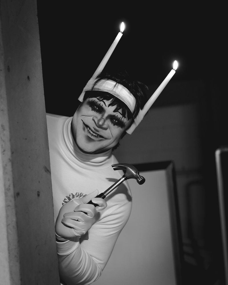 A black & white photo of Mickey cosplaying Souichi peaking around a corner 