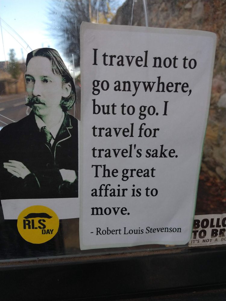 A bus stop decorated with an image of Robert Louis Stevenson along with the words "I travel not to go anywhere, but to go.  I travel for travel's sake. The great affair is to move"