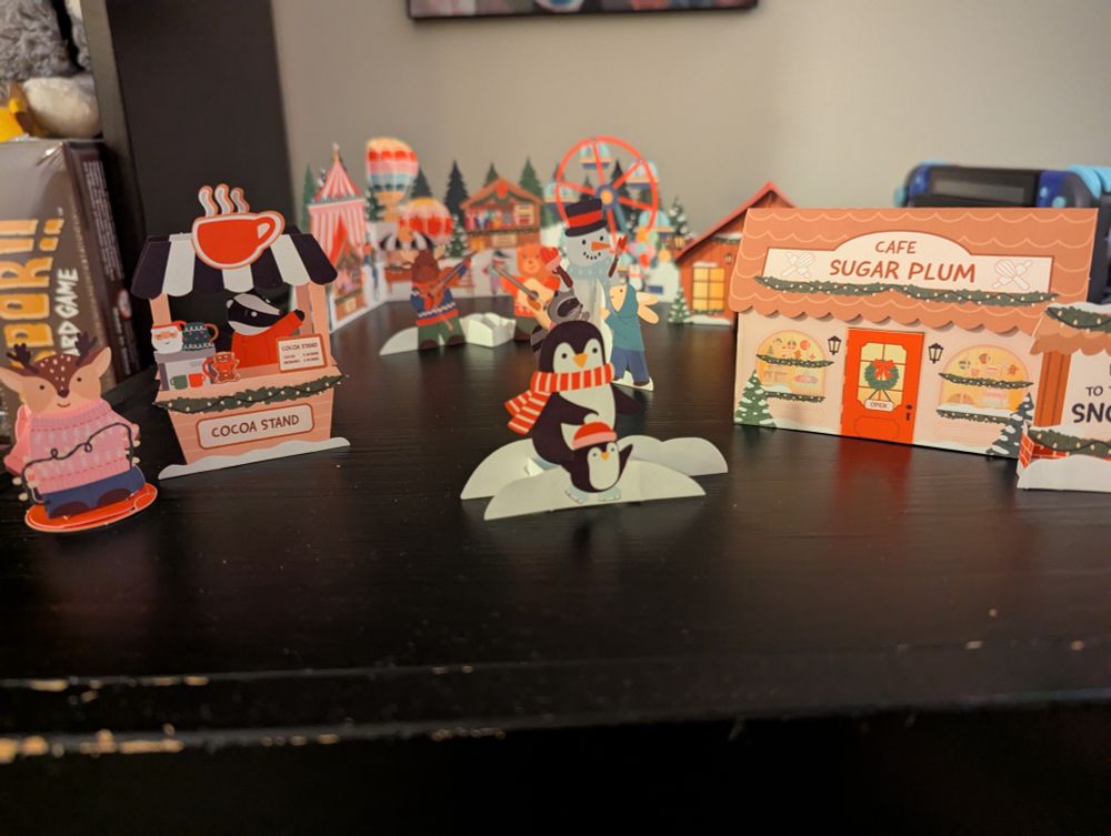 All cartoon pop ups from an Advent calendar arranged on a table to resemble a town. 