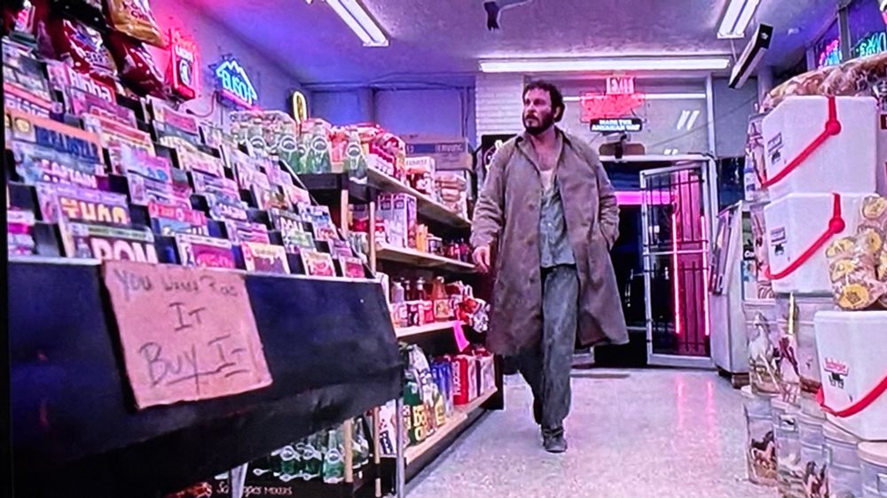 In a scene in ROBOCOP, a robber enters a convenience store and approaches a sales rack featuring comic books. Marvel’s ROM SPACEKNIGHT is visible in the front and appears largest in the frame.