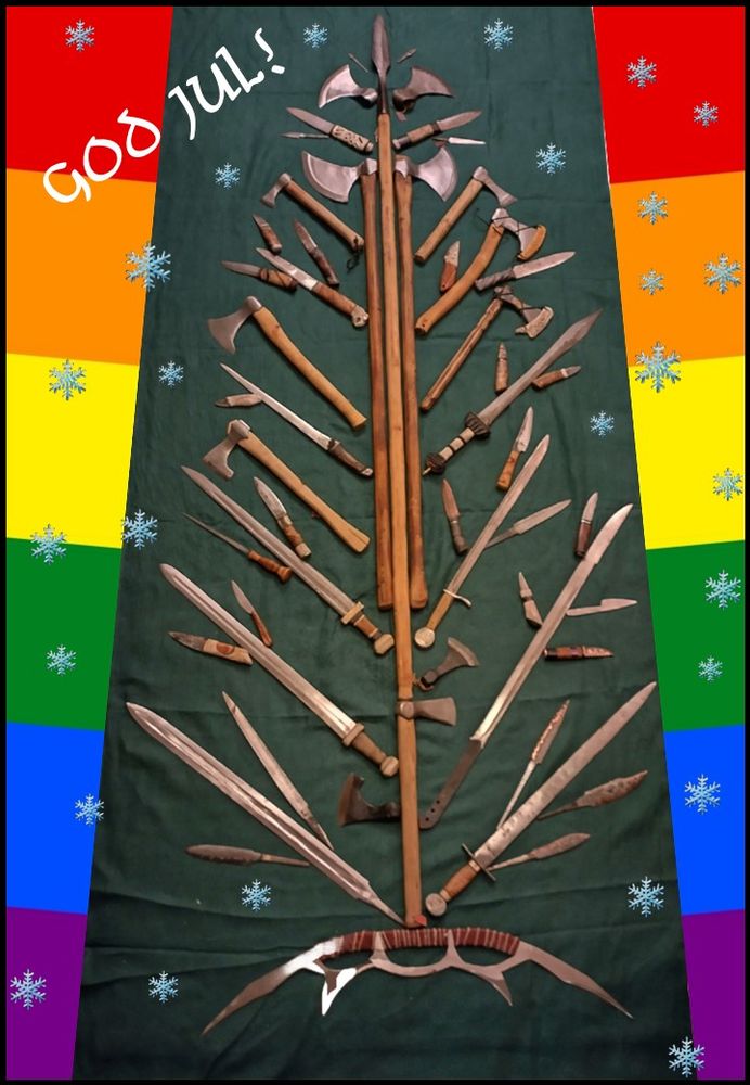 A holliday "tree" comprised of hand-forged knives, axes, a spear, and even a Bat’leth as the base, all displayed on a green fabric. Behind the tree is a border in Pride-flag rainbow colours. Overall is a sprinkling of randomly distributed snowflakes, and in the upper left corner is the Swedish text "God Jul!", which literally translates to "good yule", or more correctly to "Merry Christmas!"