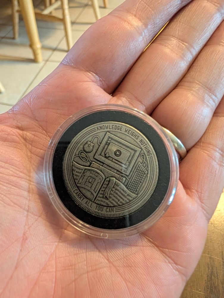 Back side of my 2,000-learner crash course coin in my palm.