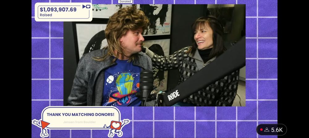 John Green as Silly Ray Cyrus and Sarah Urist Green looking at each other during the Project for Awesome 2025!