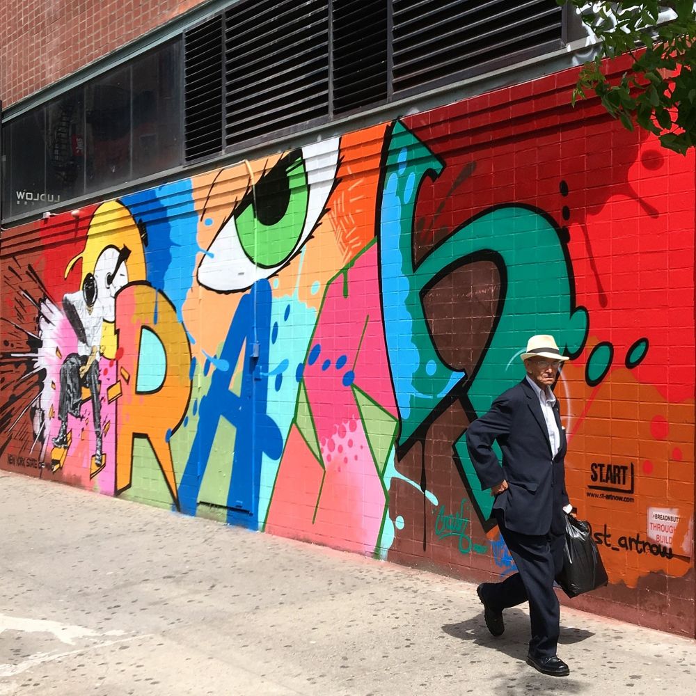 Man walks past a mural by Crash and Nick Walker for StArt on the Lower East Side in Manhattan, New York. 