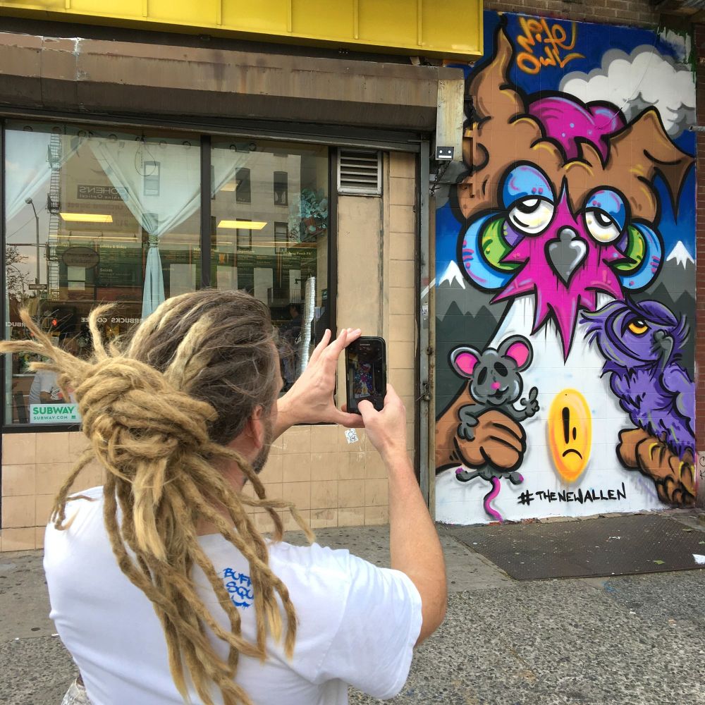 Artist Nite Owl takes a photo of his piece for the New Allen on the Lower East Side in Manhattan, New York. 