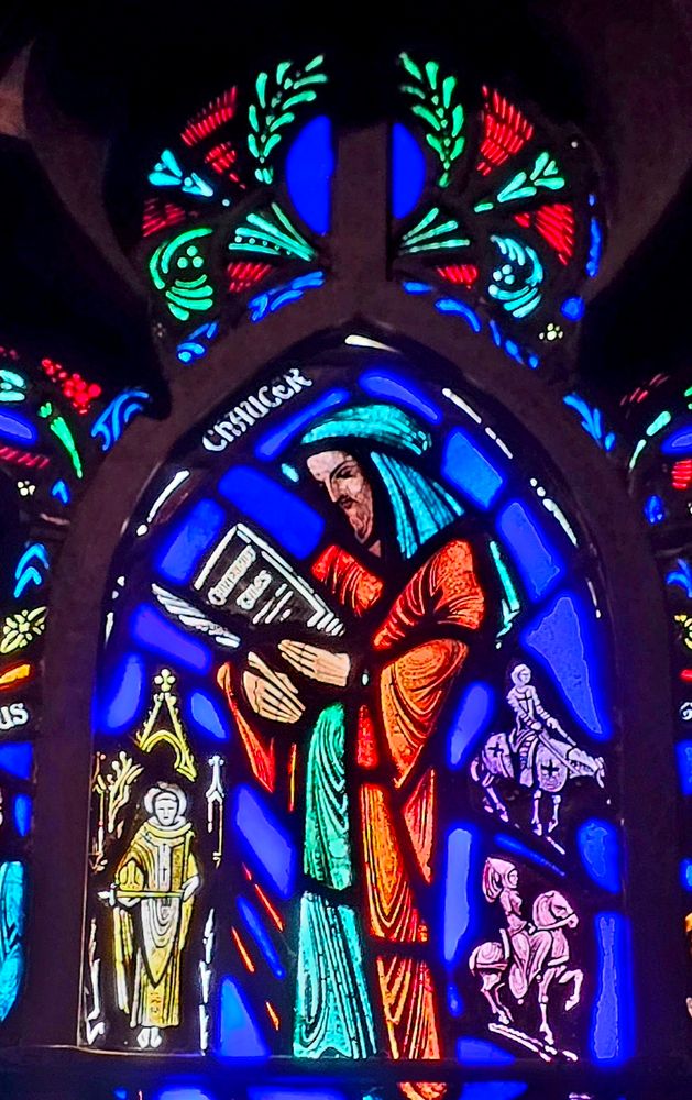 Stained glass window of Chaucer reading a book under a laurel wreath