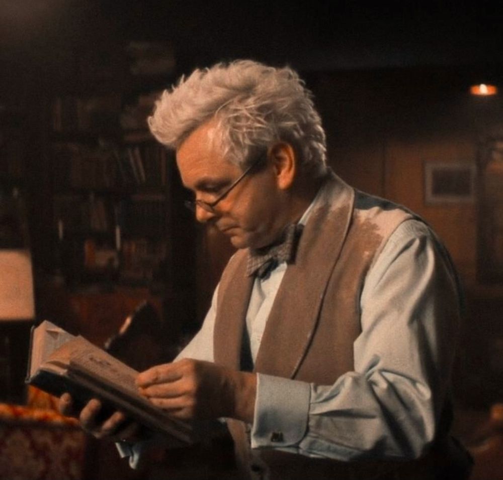 Aziraphale looking at a book, wearing his nifty glasses, looking hot.