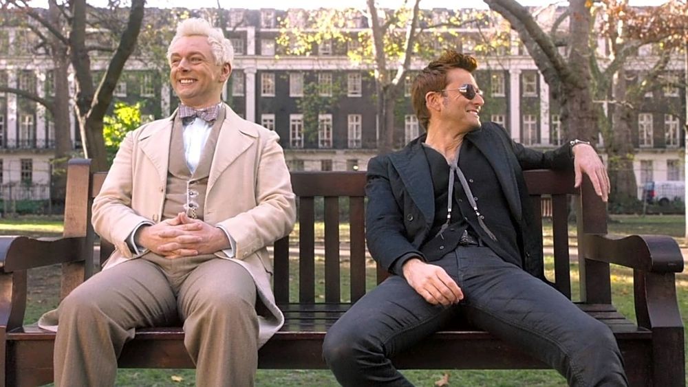 Aziraphale and Crowley sitting on the bench, both looking pleased and laughing and looking hot.