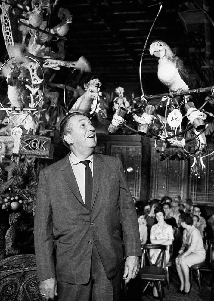 Walt Disney grins up at the audio-animatronic parrot named Jose in the original Disneyland’s enchanted tiki room. 