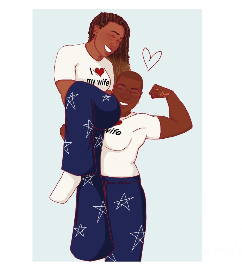 Hen Wilson holding her wife Karen Wilson on her right shoulder one handed while she’s flexing her left arm with her wedding ring visible they both have shirts that say I ❤️ my wife