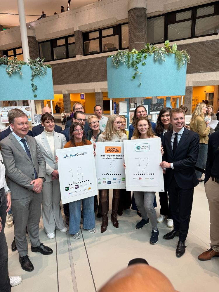 Afbeelding van kamerleden en jongeren die de petitie en het manifest omhooghouden.